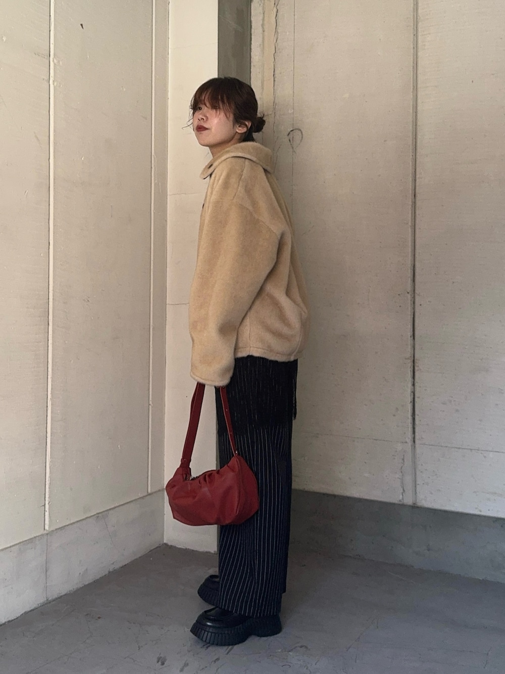 ブラック系のテーラードジャケット、レッド系のカーディガン/ボレロ、ブラック系のその他パンツを着用したレディースの冬コーディネートの3枚目の写真