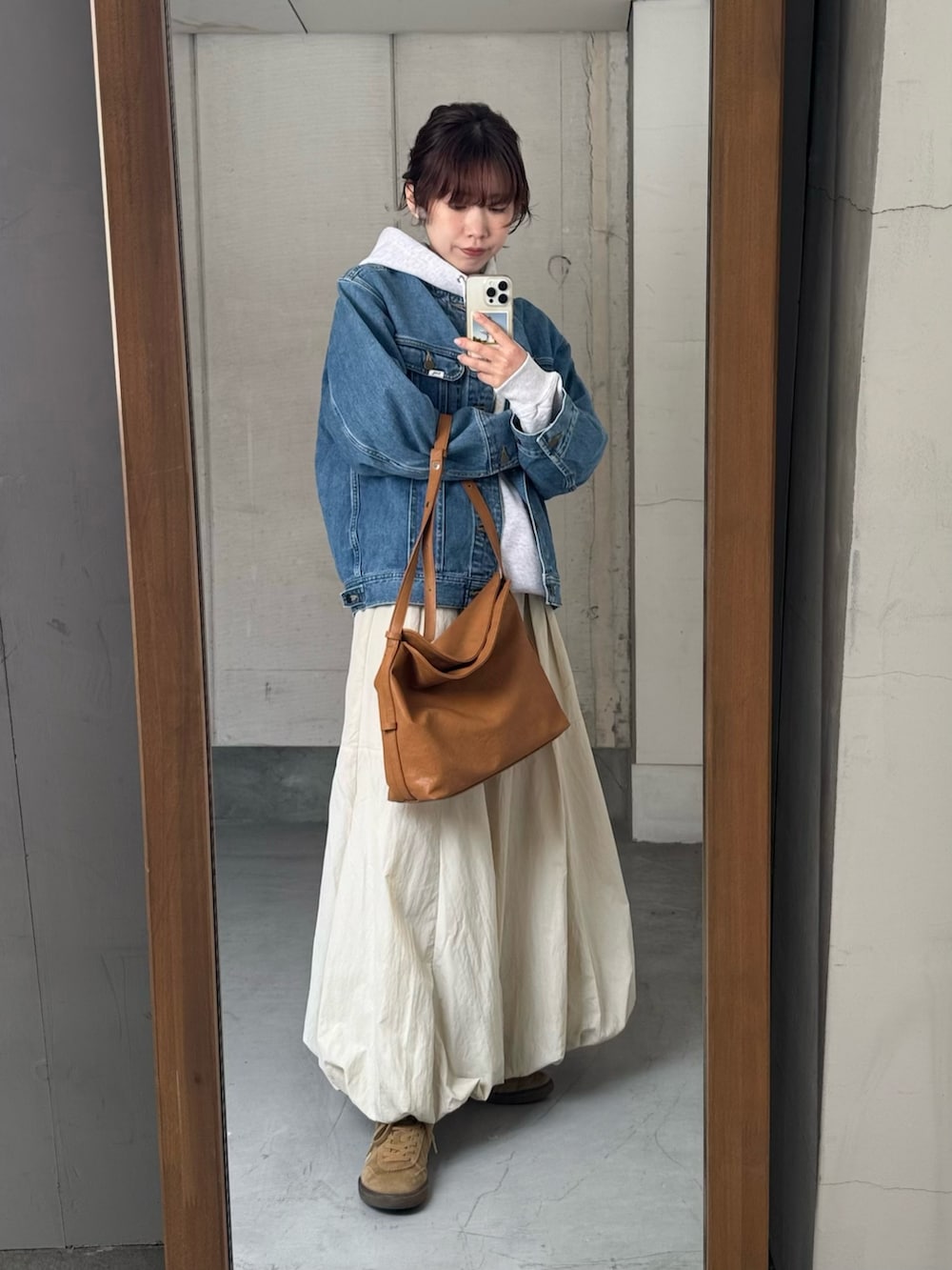 ブルー系のデニムジャケット、ベージュ系のショルダーバッグ、その他のパーカーを着用したレディースの冬コーディネートの4枚目の写真