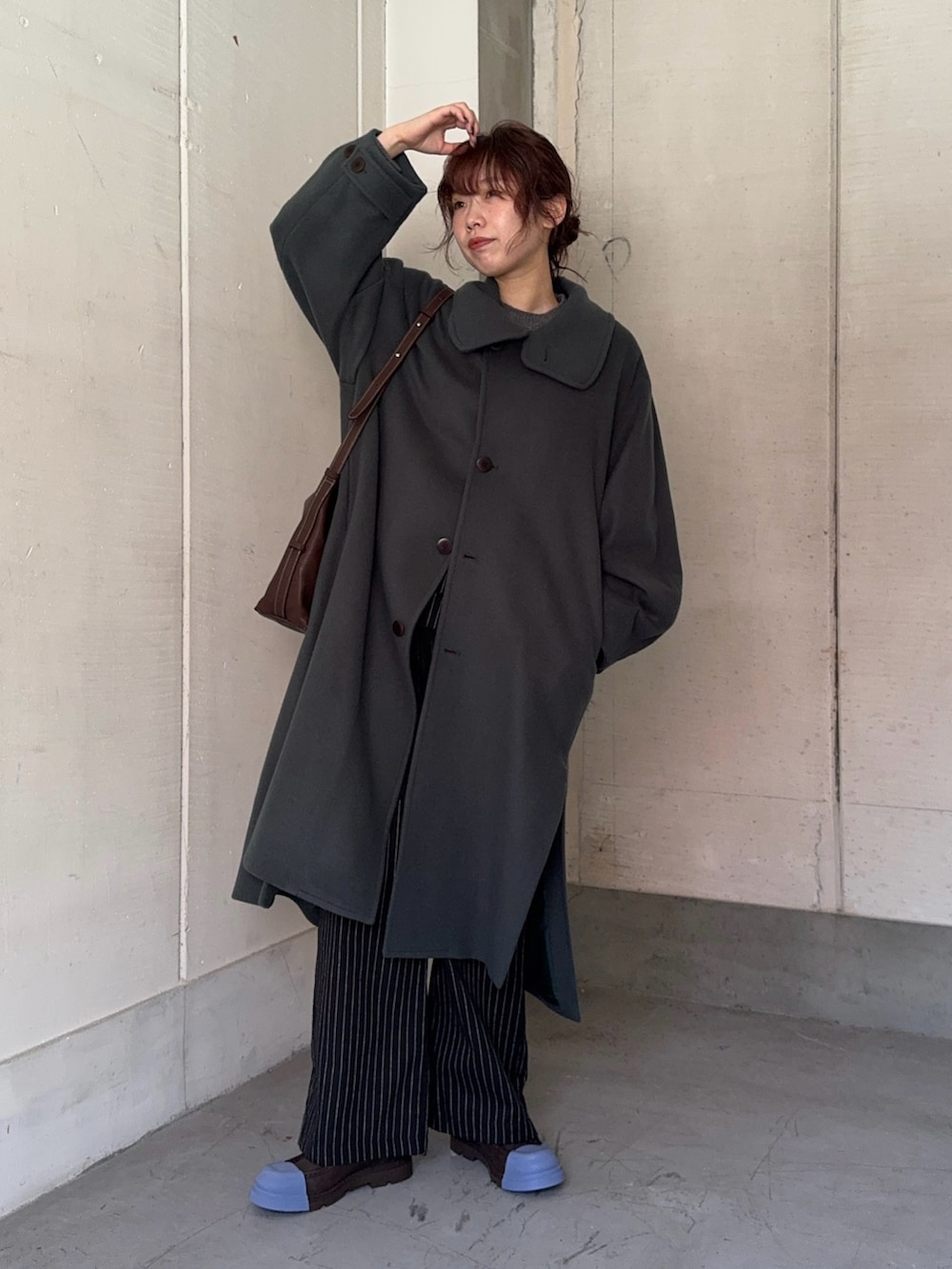 グリーン系のステンカラーコート、ブラック系のその他パンツ、ブラウン系のショルダーバッグを着用したレディースの秋コーディネートの5枚目の写真