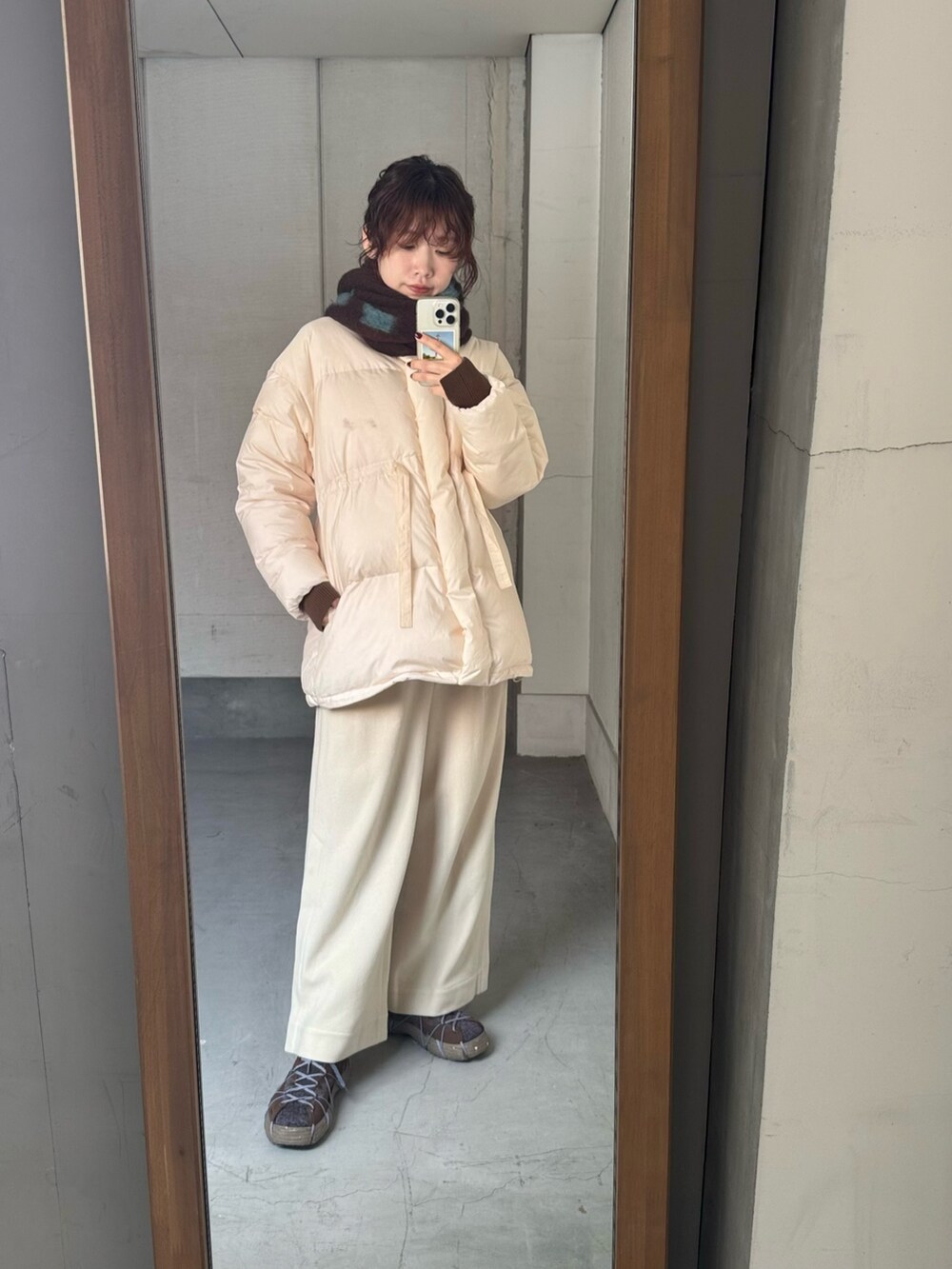 ブラウン系のスニーカー、ブラウン系のマフラーを着用したレディースの冬コーディネートの5枚目の写真