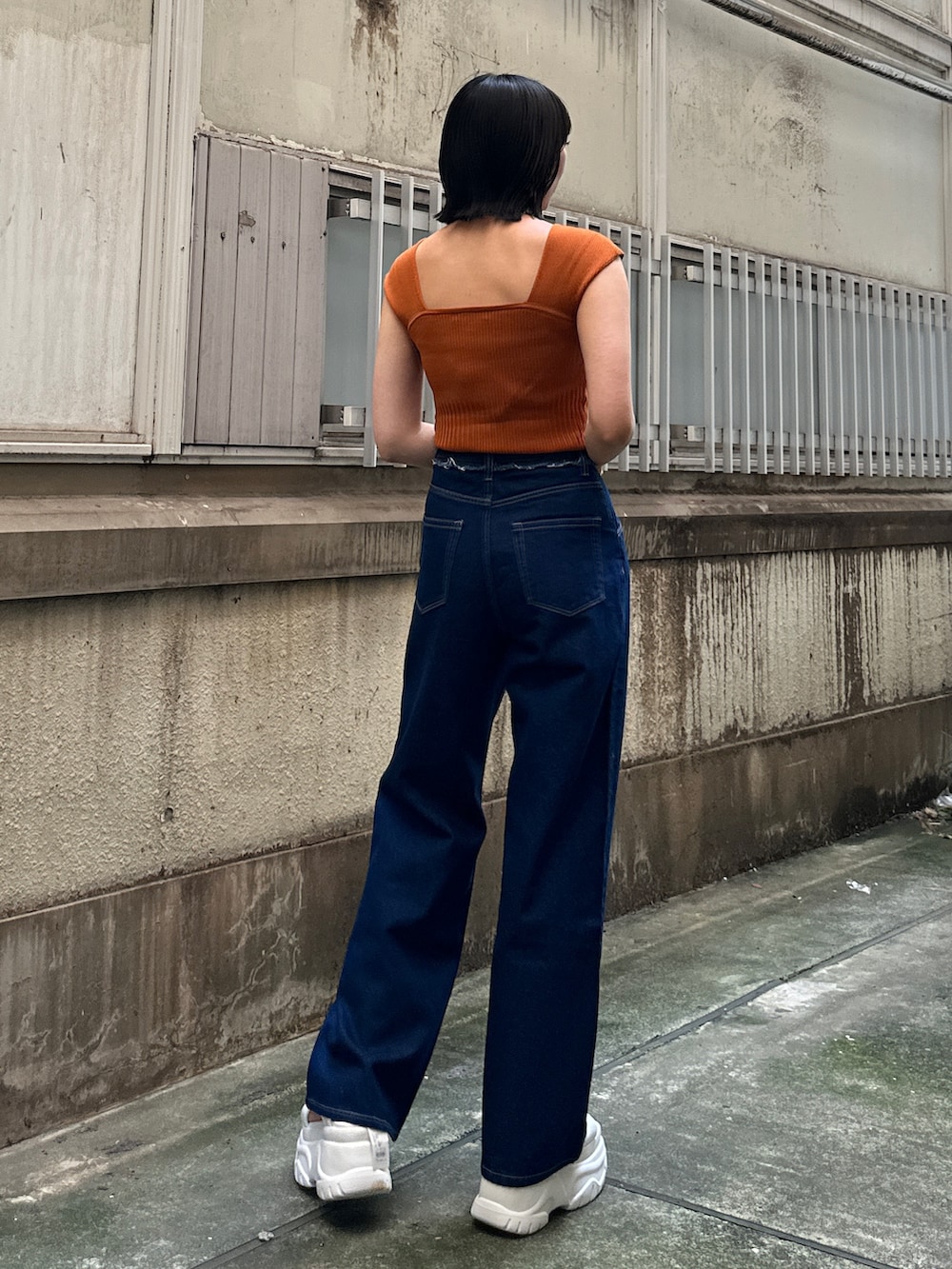 ブルー系のデニムパンツ、ホワイト系のサンダル、ブラウン系のニット/セーターを着用したレディースの夏コーディネートの3枚目の写真