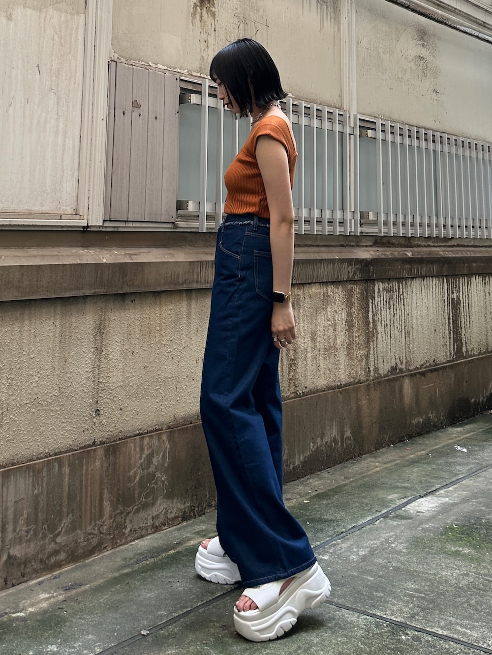 ブルー系のデニムパンツ、ホワイト系のサンダル、ブラウン系のニット/セーターを着用したレディースの夏コーディネートの2枚目の写真