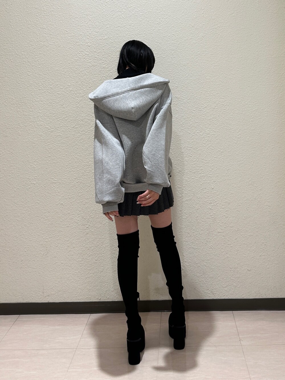 ブラック系のブルゾン、グレー系のパーカー、ブラック系のハンドバッグを着用したレディースの秋コーディネートの3枚目の写真