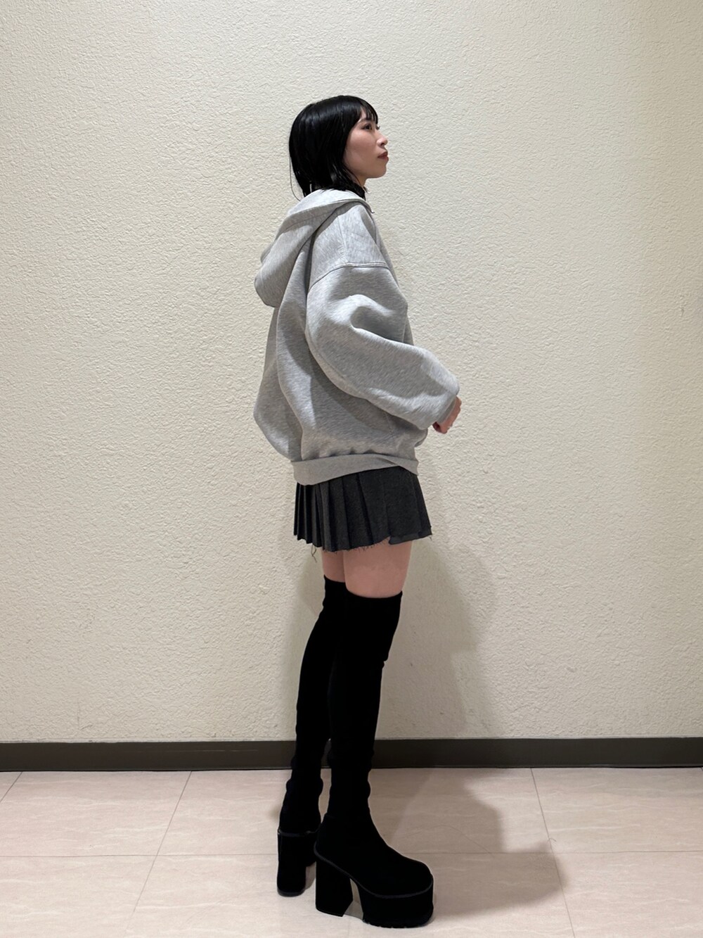 ブラック系のブルゾン、グレー系のパーカー、ブラック系のハンドバッグを着用したレディースの秋コーディネートの2枚目の写真