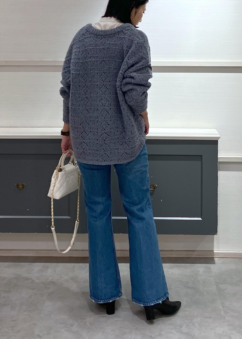 ブラック系のブーツ、ホワイト系のシャツ/ブラウス、ブルー系のニット/セーターを着用したレディースの冬コーディネートの3枚目の写真