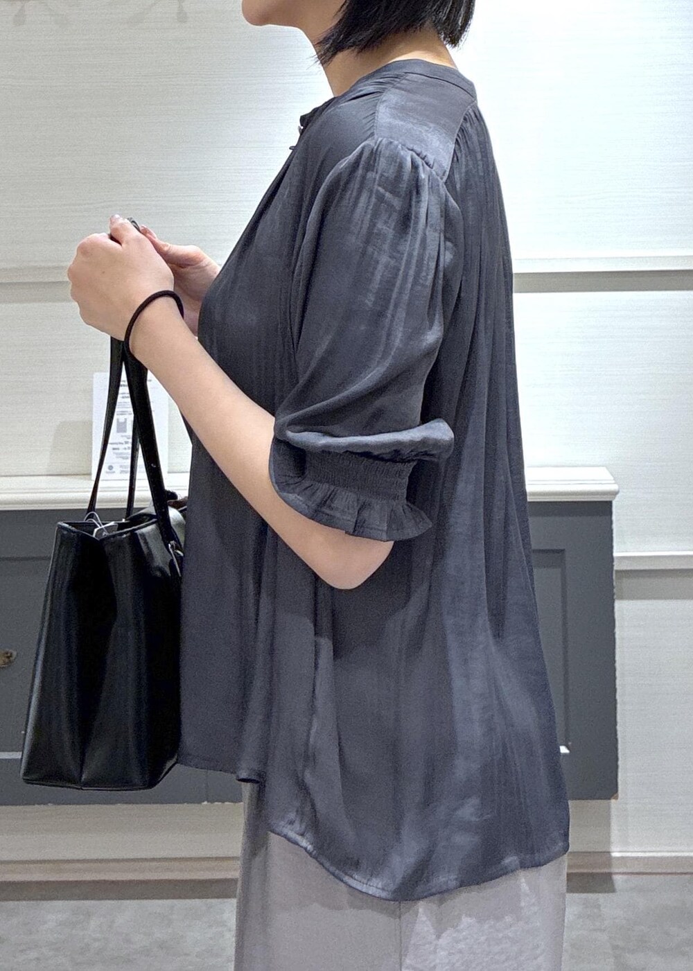 ブラック系のパンプス、ホワイト系のキャミソール、グレー系のその他パンツを着用したレディースの春コーディネートの7枚目の写真