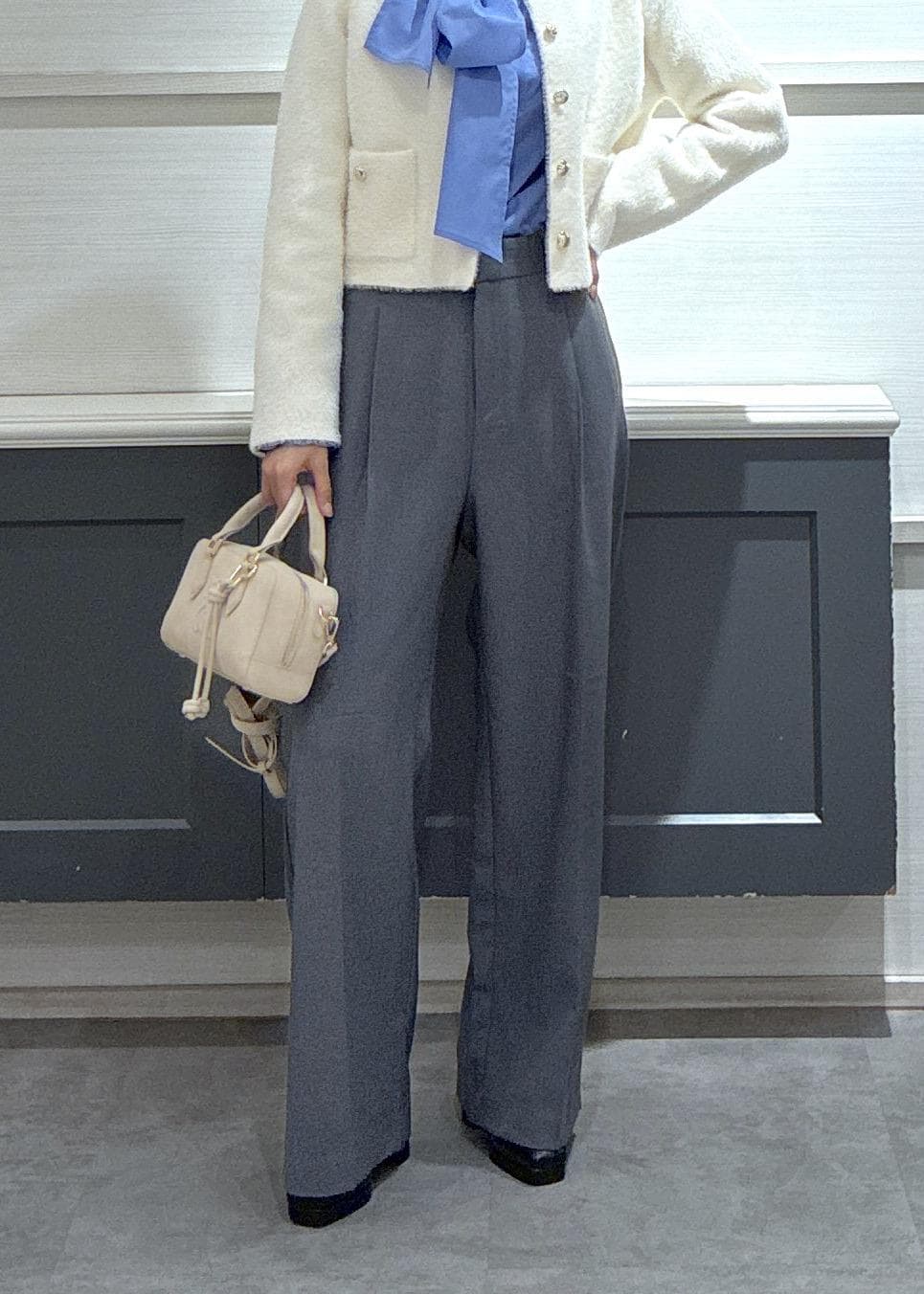 ピンク系のボストンバッグ、グレー系のスラックス、ホワイト系のカーディガン/ボレロを着用したレディースの冬コーディネートの9枚目の写真