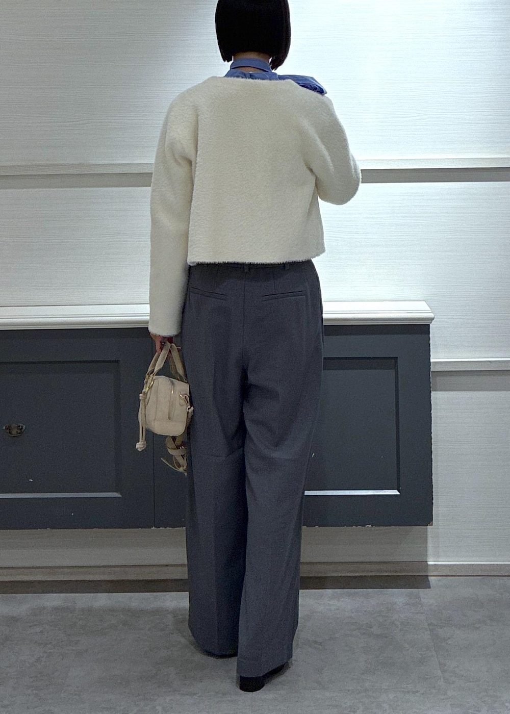 ピンク系のボストンバッグ、グレー系のスラックス、ホワイト系のカーディガン/ボレロを着用したレディースの冬コーディネートの4枚目の写真