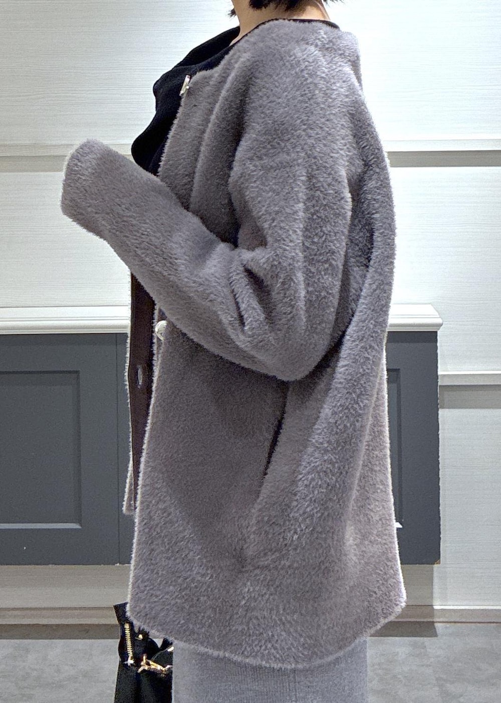 ブラック系のショルダーバッグ、ブラック系のブーツ、グレー系のスカートを着用したレディースの秋コーディネートの7枚目の写真