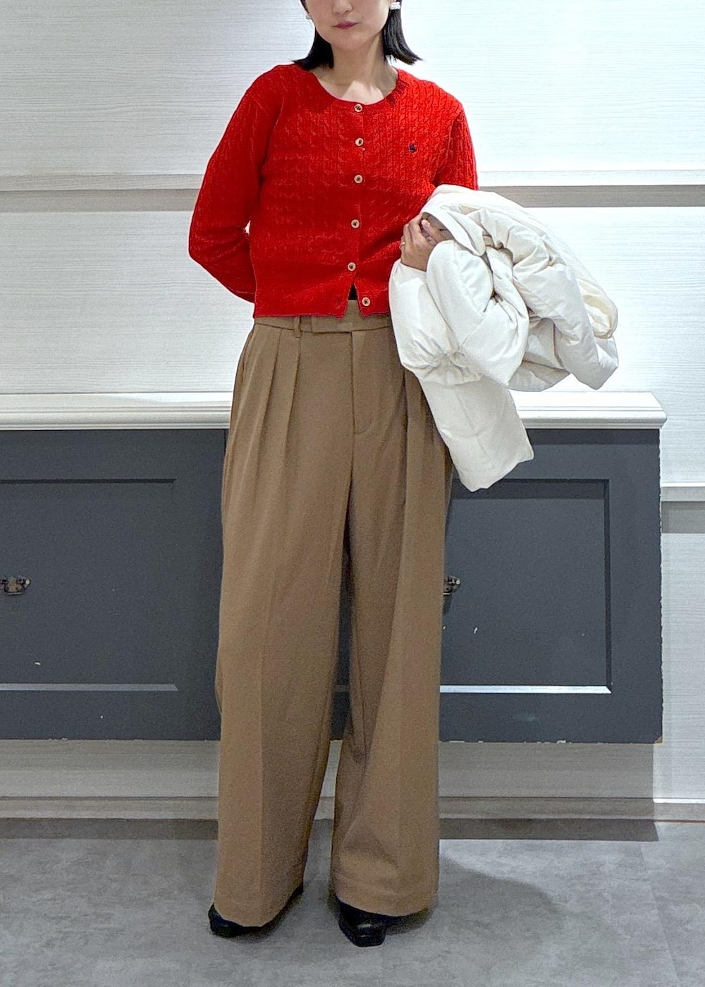 ブラック系のタンクトップ、ホワイト系のダウンジャケット/コート、ブラック系のブーツを着用したレディースの秋コーディネートの2枚目の写真