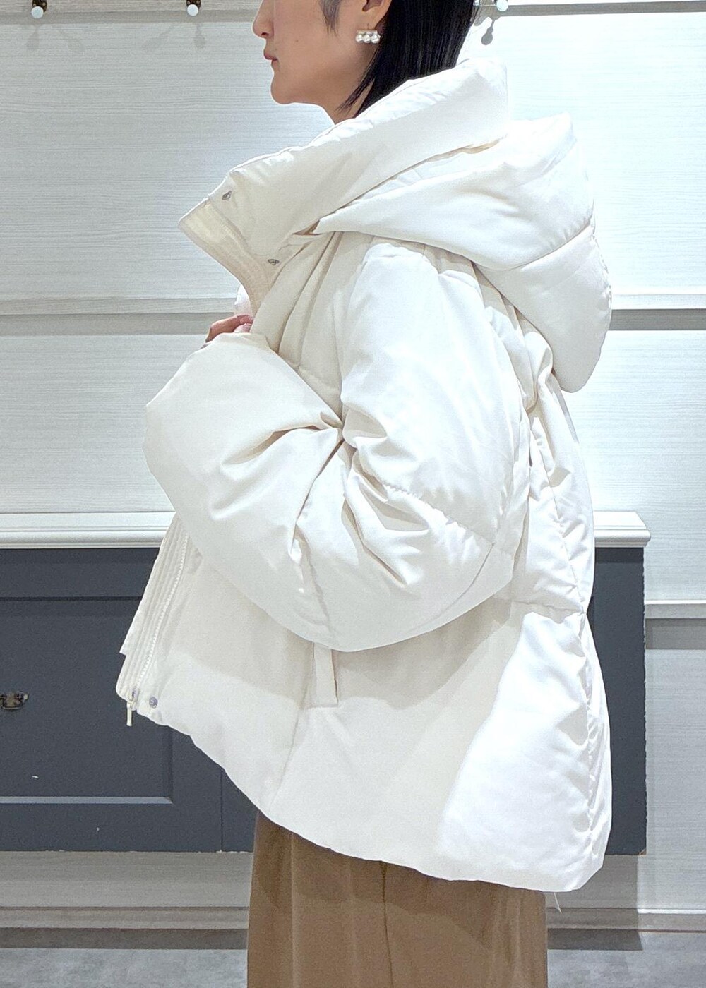 ブラック系のタンクトップ、ホワイト系のダウンジャケット/コート、ブラック系のブーツを着用したレディースの秋コーディネートの9枚目の写真