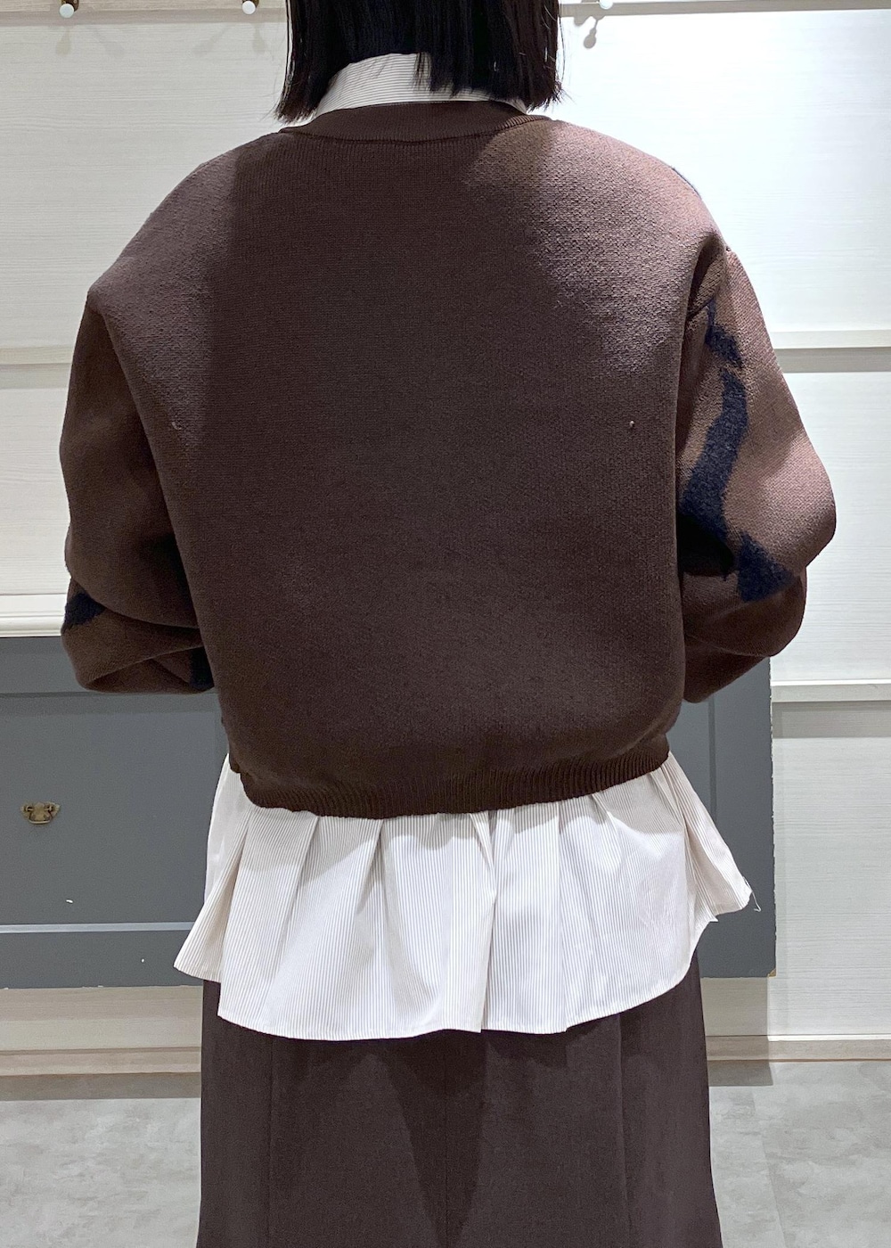 ブラウン系のスカート、ブラウン系のカーディガン/ボレロ、ピンク系のショルダーバッグを着用したレディースの秋コーディネートの7枚目の写真