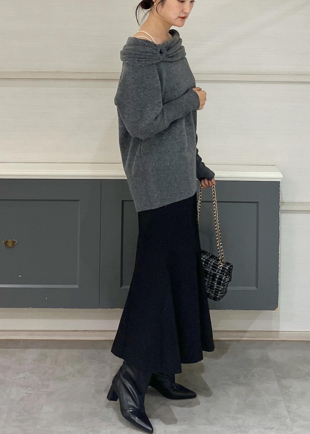 ホワイト系のキャミソール、ブラック系のブーツ、ブラック系のショルダーバッグを着用したレディースの秋コーディネートの2枚目の写真