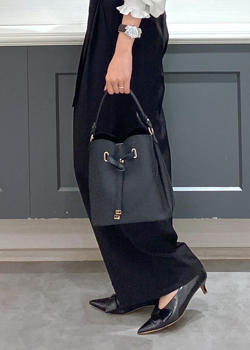 ブラック系のパンプス、ブラック系のショルダーバッグ、ブラック系のスラックスを着用したレディースの夏コーディネートの9枚目の写真