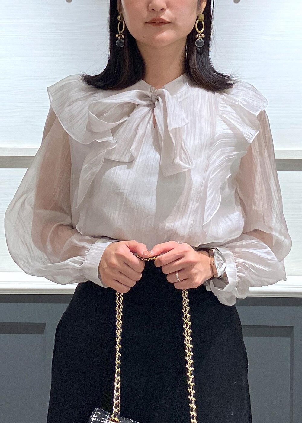 ブラック系のキャミソール、ブラック系のブーツ、ブラック系のショルダーバッグを着用したレディースの秋コーディネートの5枚目の写真