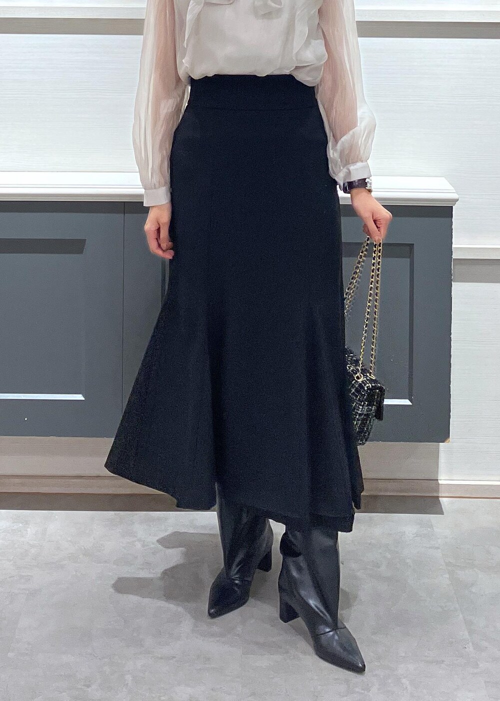 ブラック系のキャミソール、ブラック系のブーツ、ブラック系のショルダーバッグを着用したレディースの秋コーディネートの9枚目の写真