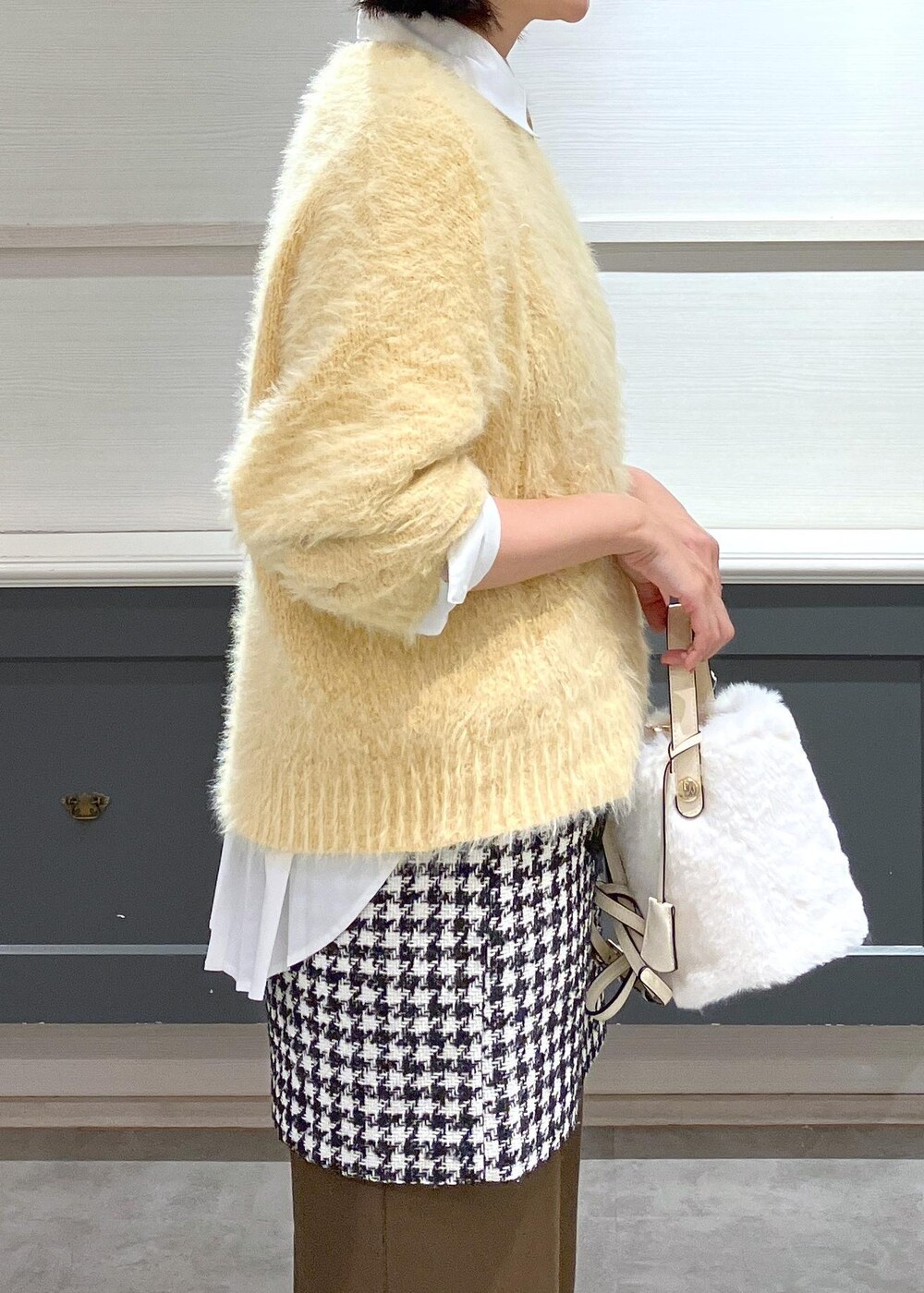 シルバー系のパンプス、ブラック系のスカート、ホワイト系のシャツ/ブラウスを着用したレディースの冬コーディネートの6枚目の写真