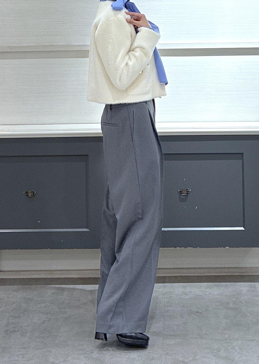 ピンク系のボストンバッグ、グレー系のスラックス、ホワイト系のカーディガン/ボレロを着用したレディースの冬コーディネートの3枚目の写真