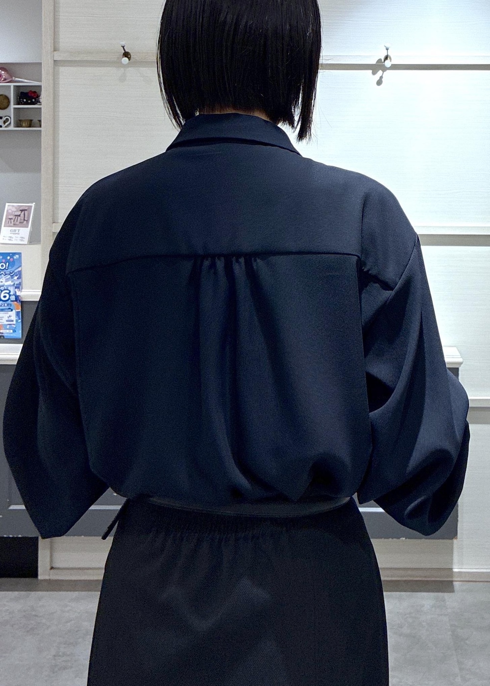 ブルー系のシャツ/ブラウス、ブラック系のローファー、ベージュ系のショルダーバッグを着用したレディースの冬コーディネートの6枚目の写真