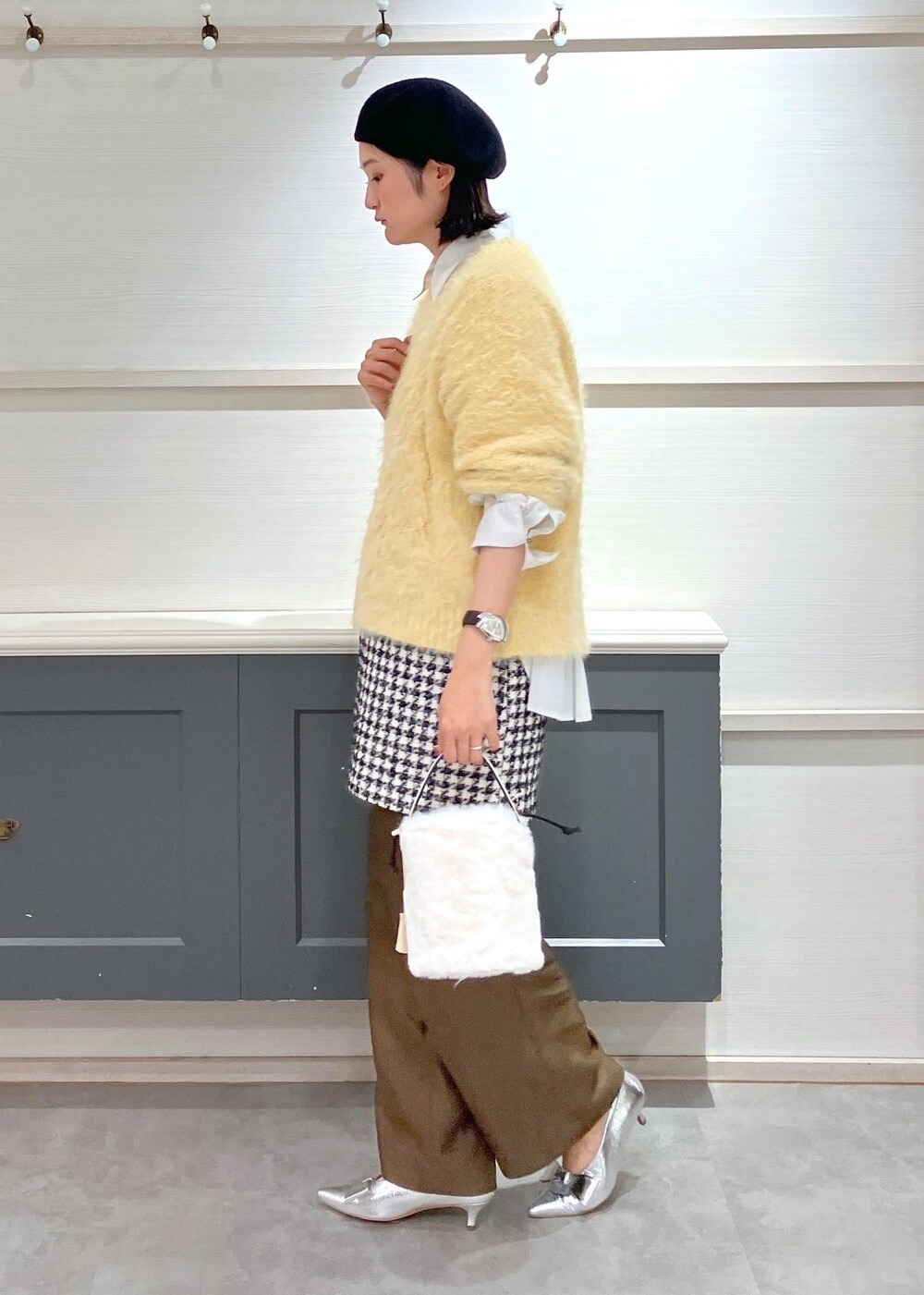 シルバー系のパンプス、ブラック系のスカート、ホワイト系のシャツ/ブラウスを着用したレディースの冬コーディネートの3枚目の写真