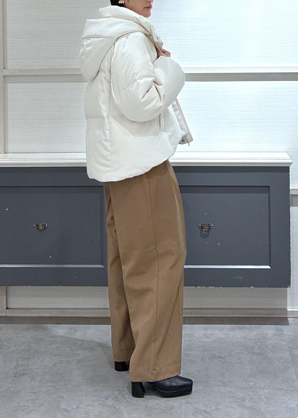 ブラック系のタンクトップ、ホワイト系のダウンジャケット/コート、ブラック系のブーツを着用したレディースの秋コーディネートの4枚目の写真