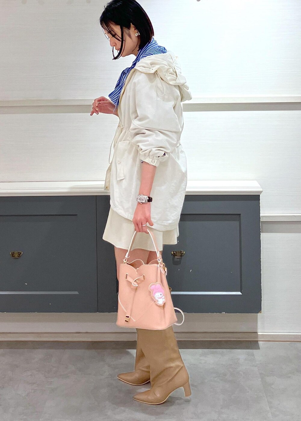 ベージュ系のブーツ、ホワイト系のスカート、ブルー系のシャツ/ブラウスを着用したレディースの冬コーディネートの2枚目の写真