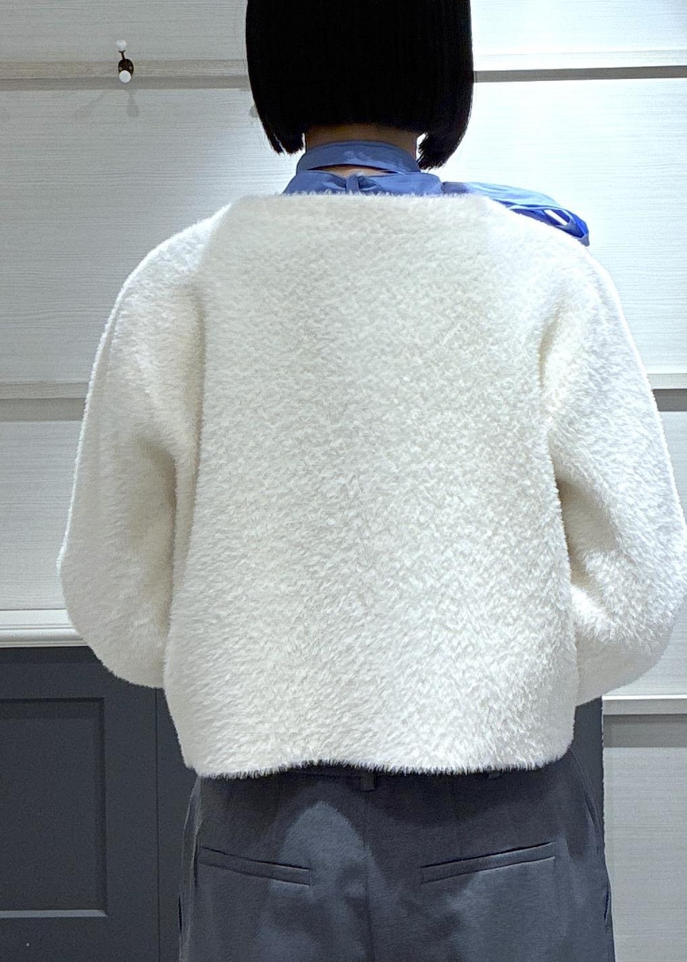 ピンク系のボストンバッグ、グレー系のスラックス、ホワイト系のカーディガン/ボレロを着用したレディースの冬コーディネートの8枚目の写真