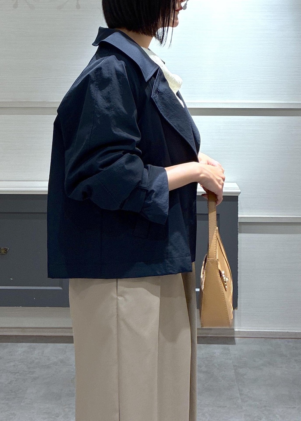 イエロー系のショルダーバッグ、ブラック系のパンプス、ブルー系のトレンチコートを着用したレディースの春コーディネートの10枚目の写真