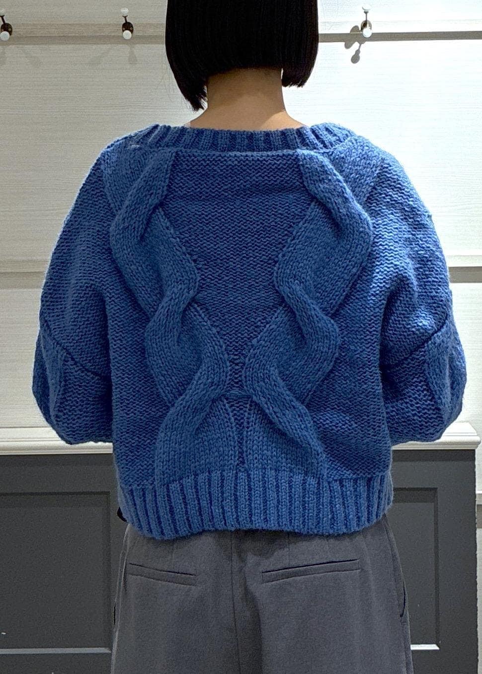 ブラック系のショルダーバッグ、グレー系のスラックス、ブラック系のブーツを着用したレディースの冬コーディネートの6枚目の写真