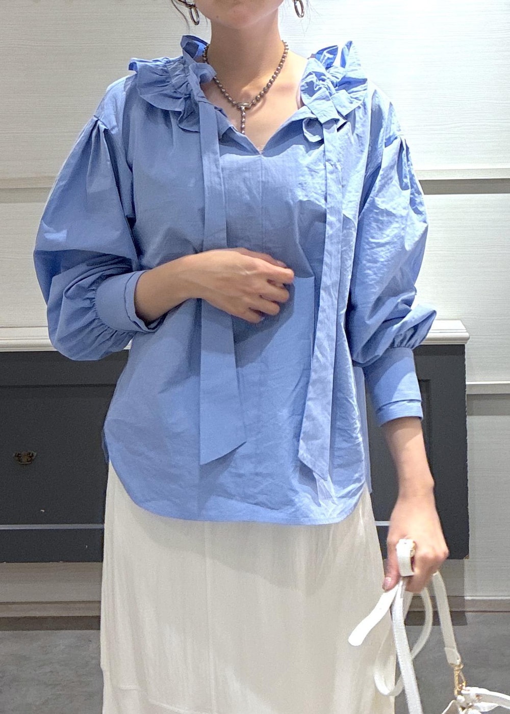 ホワイト系のショルダーバッグ、ベージュ系のパンプス、ホワイト系のキャミソールを着用したレディースの春コーディネートの6枚目の写真