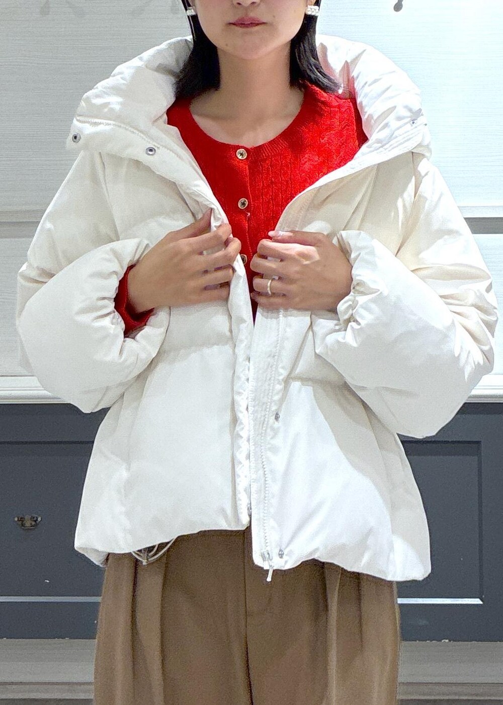 ブラック系のタンクトップ、ホワイト系のダウンジャケット/コート、ブラック系のブーツを着用したレディースの秋コーディネートの6枚目の写真