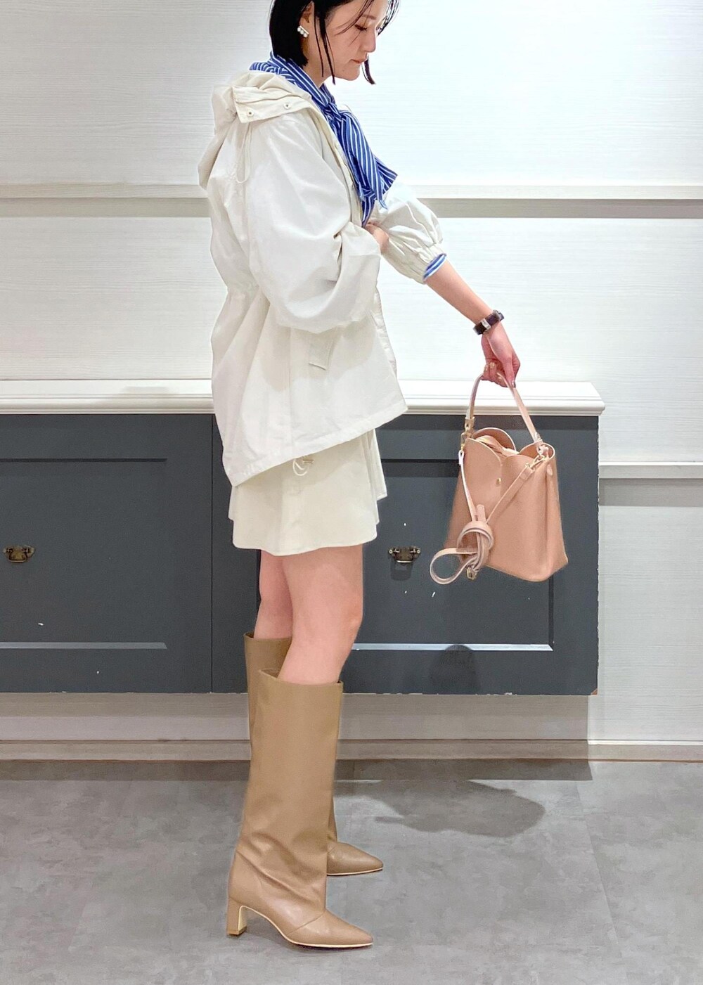 ベージュ系のブーツ、ホワイト系のスカート、ブルー系のシャツ/ブラウスを着用したレディースの冬コーディネートの3枚目の写真