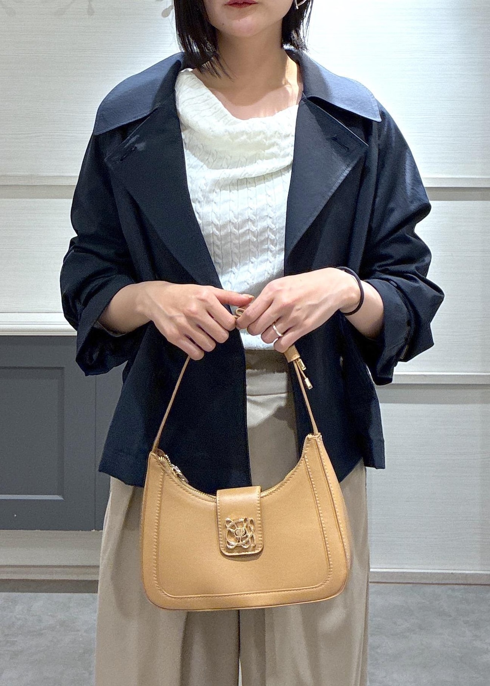 イエロー系のショルダーバッグ、ブラック系のパンプス、ブルー系のトレンチコートを着用したレディースの春コーディネートの7枚目の写真