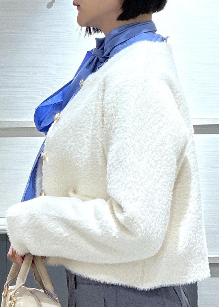 ピンク系のボストンバッグ、グレー系のスラックス、ホワイト系のカーディガン/ボレロを着用したレディースの冬コーディネートの7枚目の写真