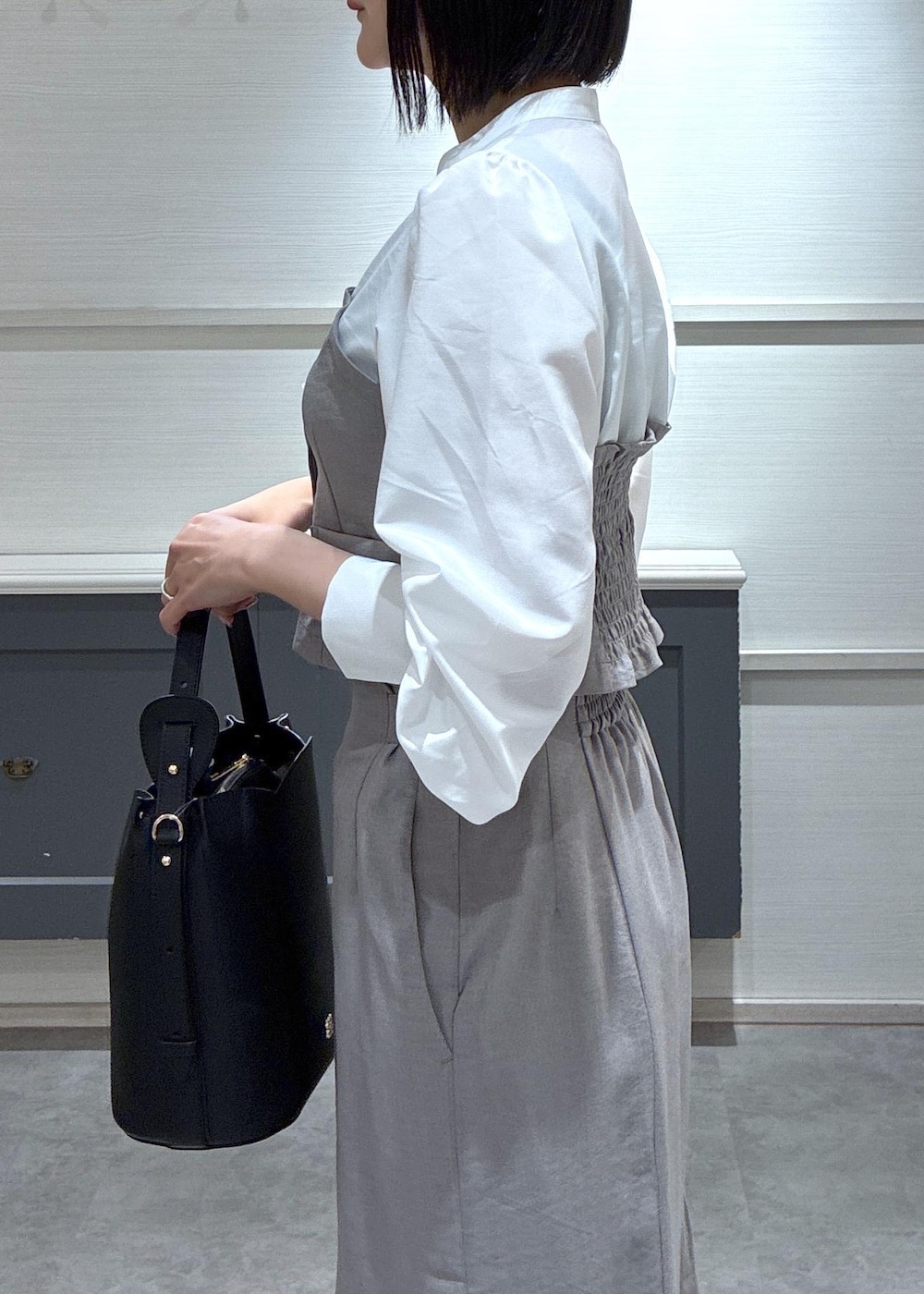 ブラック系のショルダーバッグ、ブラック系のローファー、グレー系のスカートを着用したレディースの春コーディネートの8枚目の写真