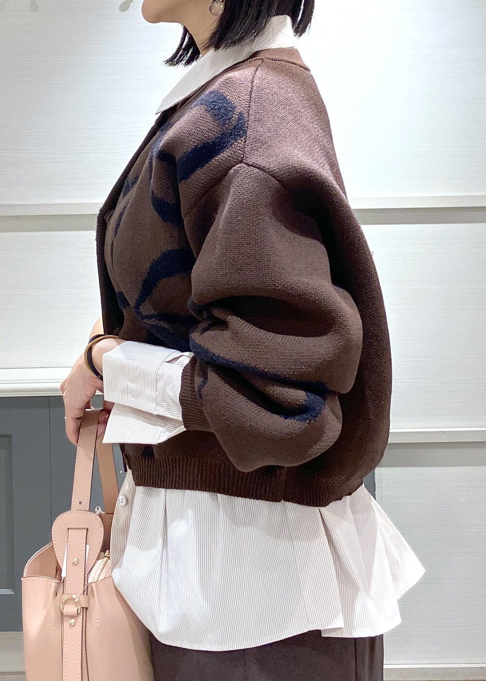 ブラウン系のスカート、ブラウン系のカーディガン/ボレロ、ピンク系のショルダーバッグを着用したレディースの秋コーディネートの8枚目の写真