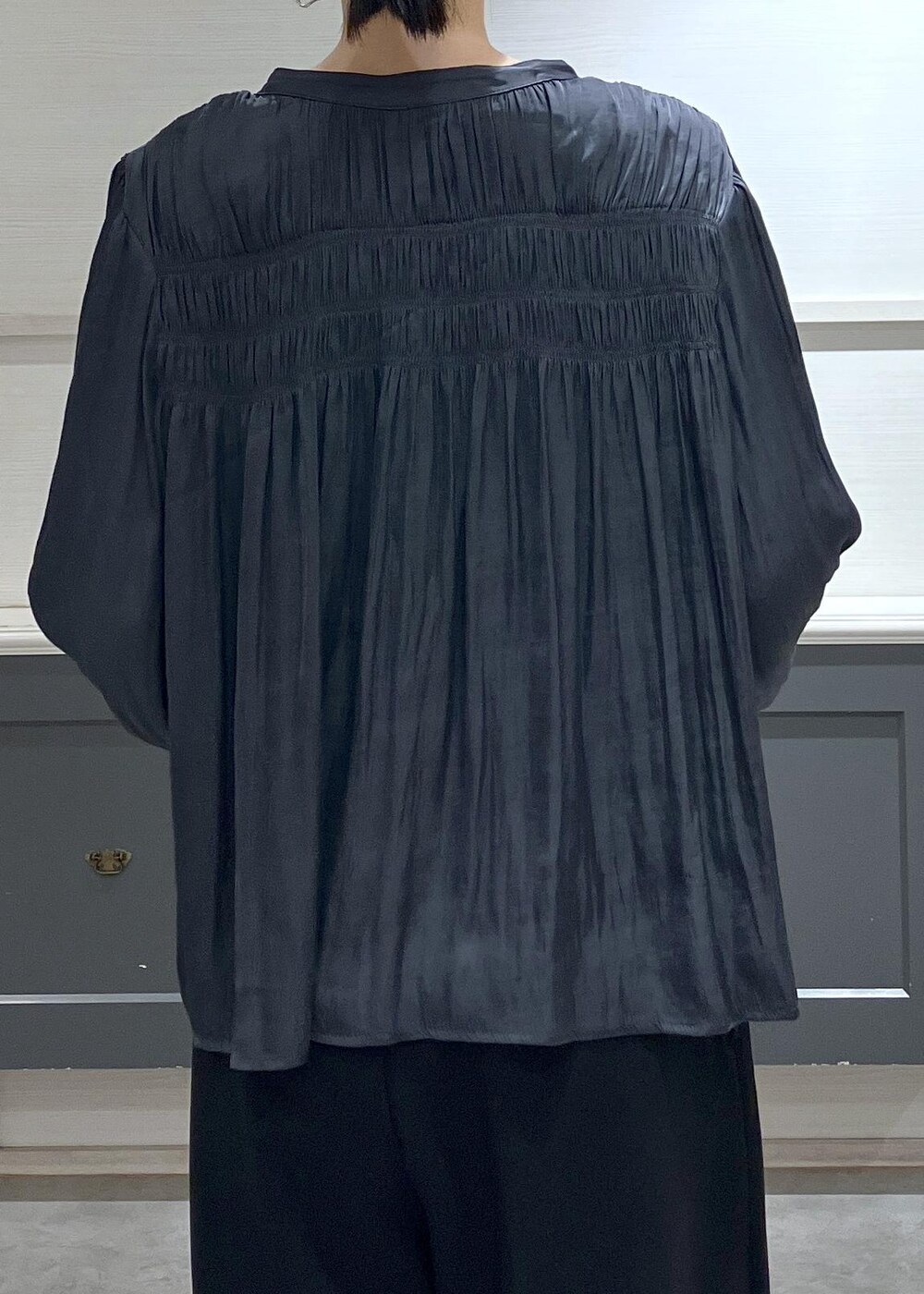 ホワイト系のキャミソール、グレー系のショルダーバッグ、ブラック系のスラックスを着用したレディースの秋コーディネートの6枚目の写真