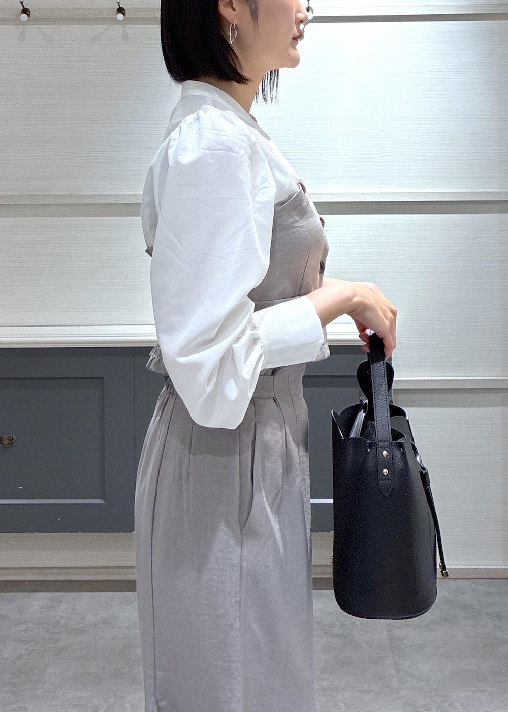 ブラック系のショルダーバッグ、ブラック系のローファー、グレー系のスカートを着用したレディースの春コーディネートの9枚目の写真