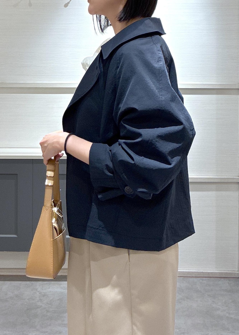 イエロー系のショルダーバッグ、ブラック系のパンプス、ブルー系のトレンチコートを着用したレディースの春コーディネートの9枚目の写真