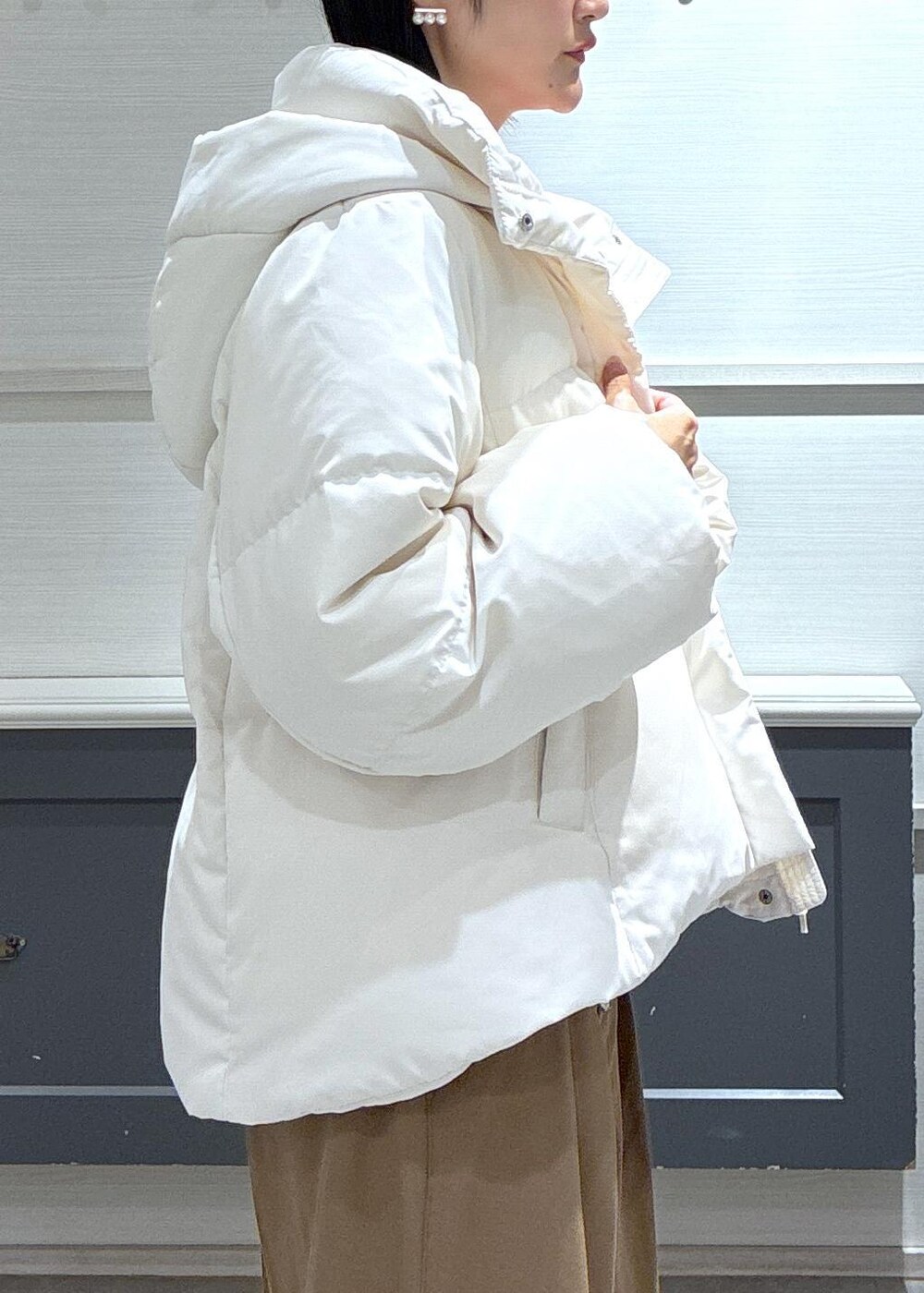 ブラック系のタンクトップ、ホワイト系のダウンジャケット/コート、ブラック系のブーツを着用したレディースの秋コーディネートの8枚目の写真