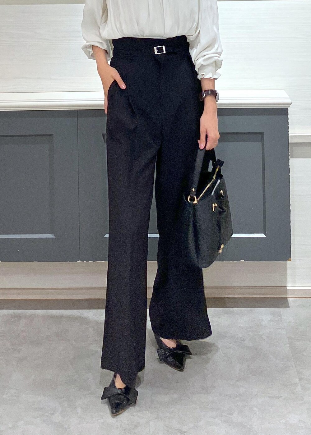 ブラック系のパンプス、ブラック系のショルダーバッグ、ブラック系のスラックスを着用したレディースの夏コーディネートの4枚目の写真