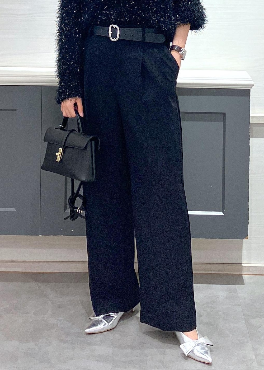 シルバー系のパンプス、ブラック系のショルダーバッグ、ブラック系のスラックスを着用したレディースの冬コーディネートの9枚目の写真