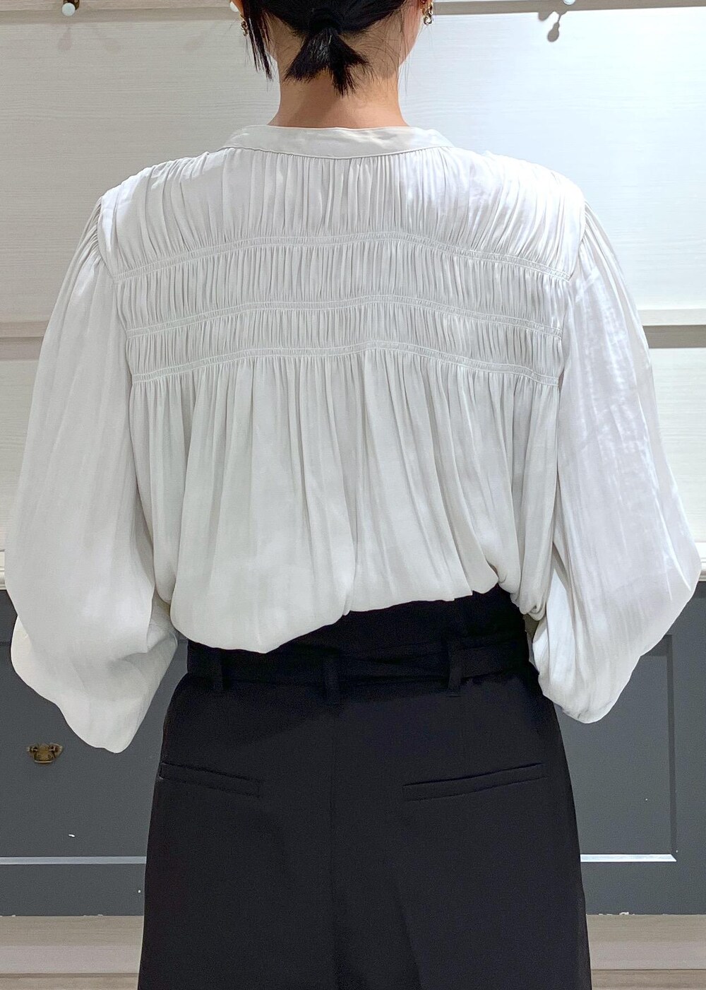 ブラック系のパンプス、ブラック系のショルダーバッグ、ブラック系のスラックスを着用したレディースの夏コーディネートの6枚目の写真