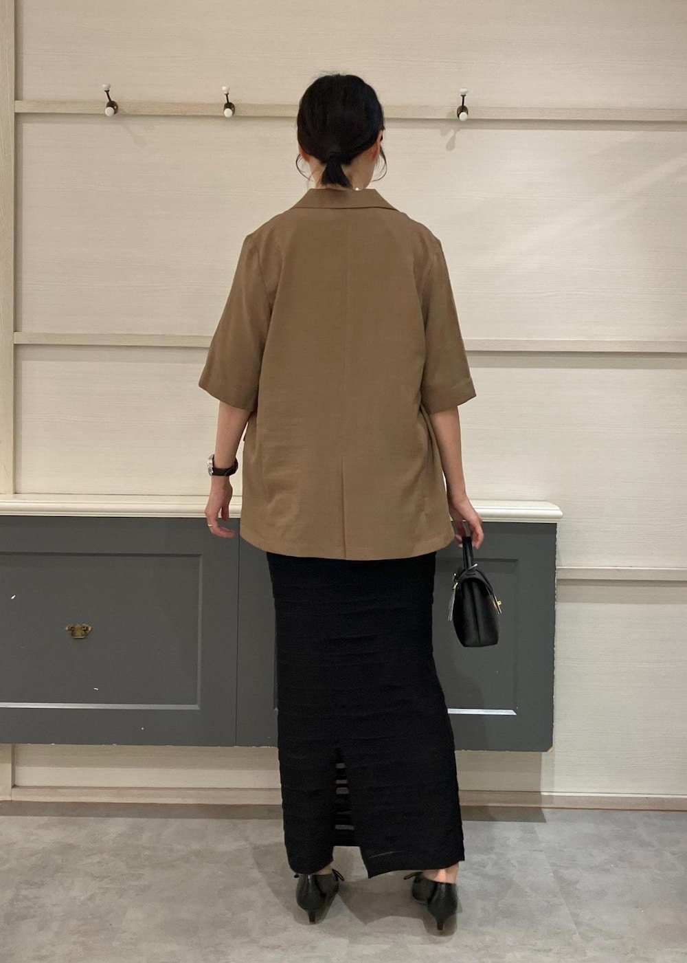 ブラック系のショルダーバッグ、ブラック系のパンプス、ブラック系のキャミソールを着用したレディースの夏コーディネートの6枚目の写真