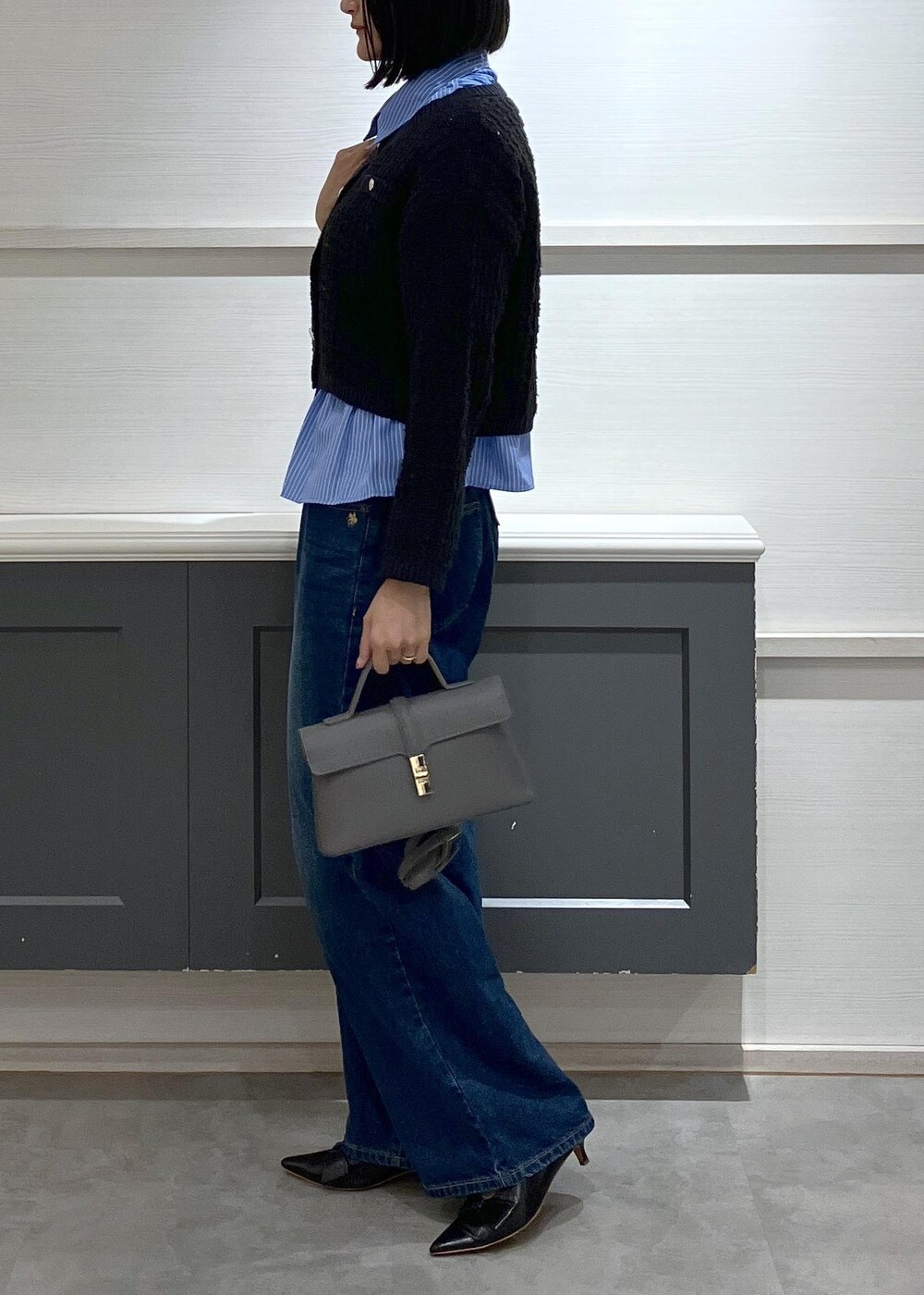 ブラック系のパンプス、グレー系のショルダーバッグ、ブルー系のシャツ/ブラウスを着用したレディースの秋コーディネートの2枚目の写真