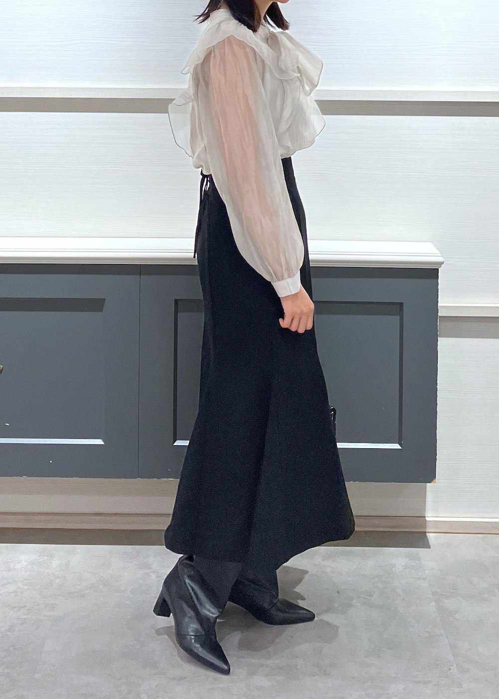 ブラック系のキャミソール、ブラック系のブーツ、ブラック系のショルダーバッグを着用したレディースの秋コーディネートの3枚目の写真