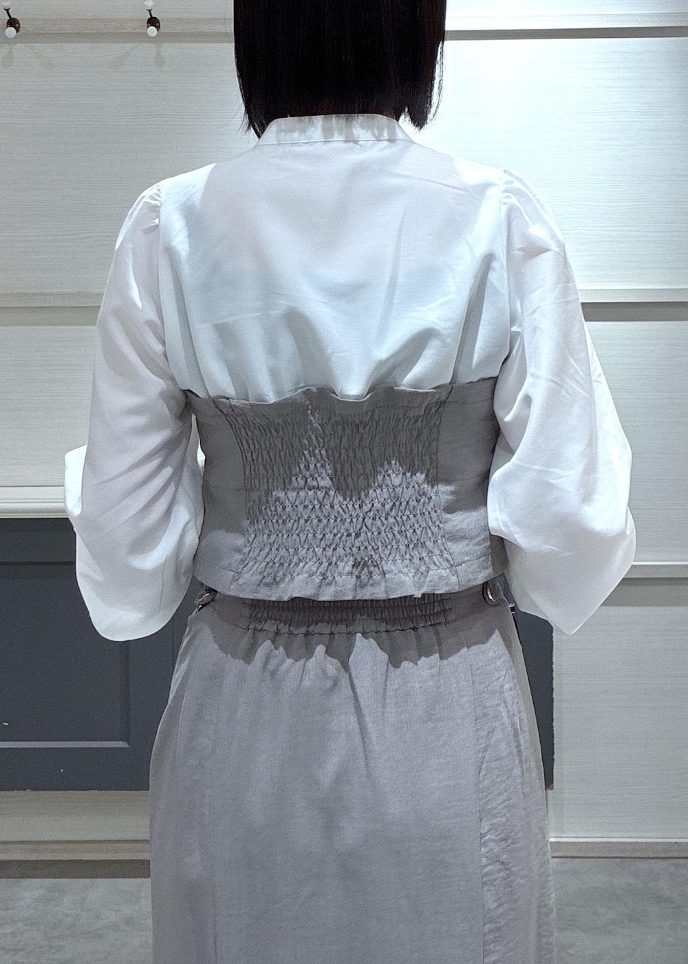 ブラック系のショルダーバッグ、ブラック系のローファー、グレー系のスカートを着用したレディースの春コーディネートの7枚目の写真