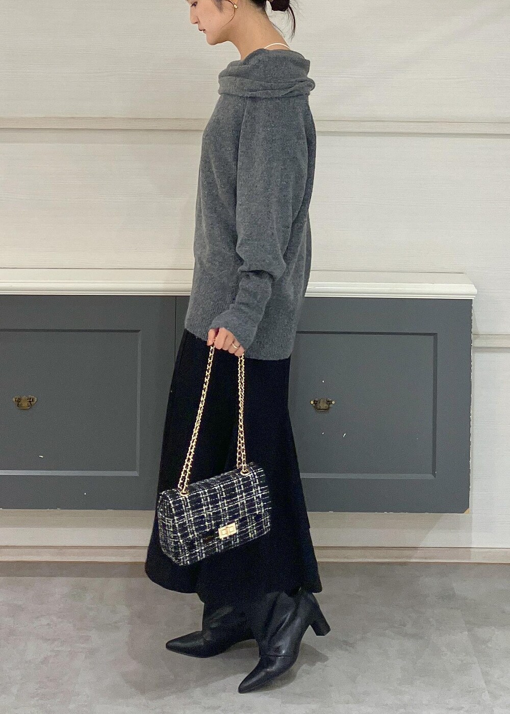 ホワイト系のキャミソール、ブラック系のブーツ、ブラック系のショルダーバッグを着用したレディースの秋コーディネートの4枚目の写真