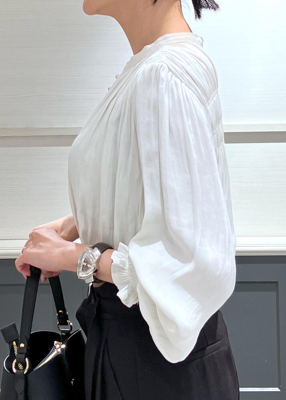 ブラック系のパンプス、ブラック系のショルダーバッグ、ブラック系のスラックスを着用したレディースの夏コーディネートの8枚目の写真