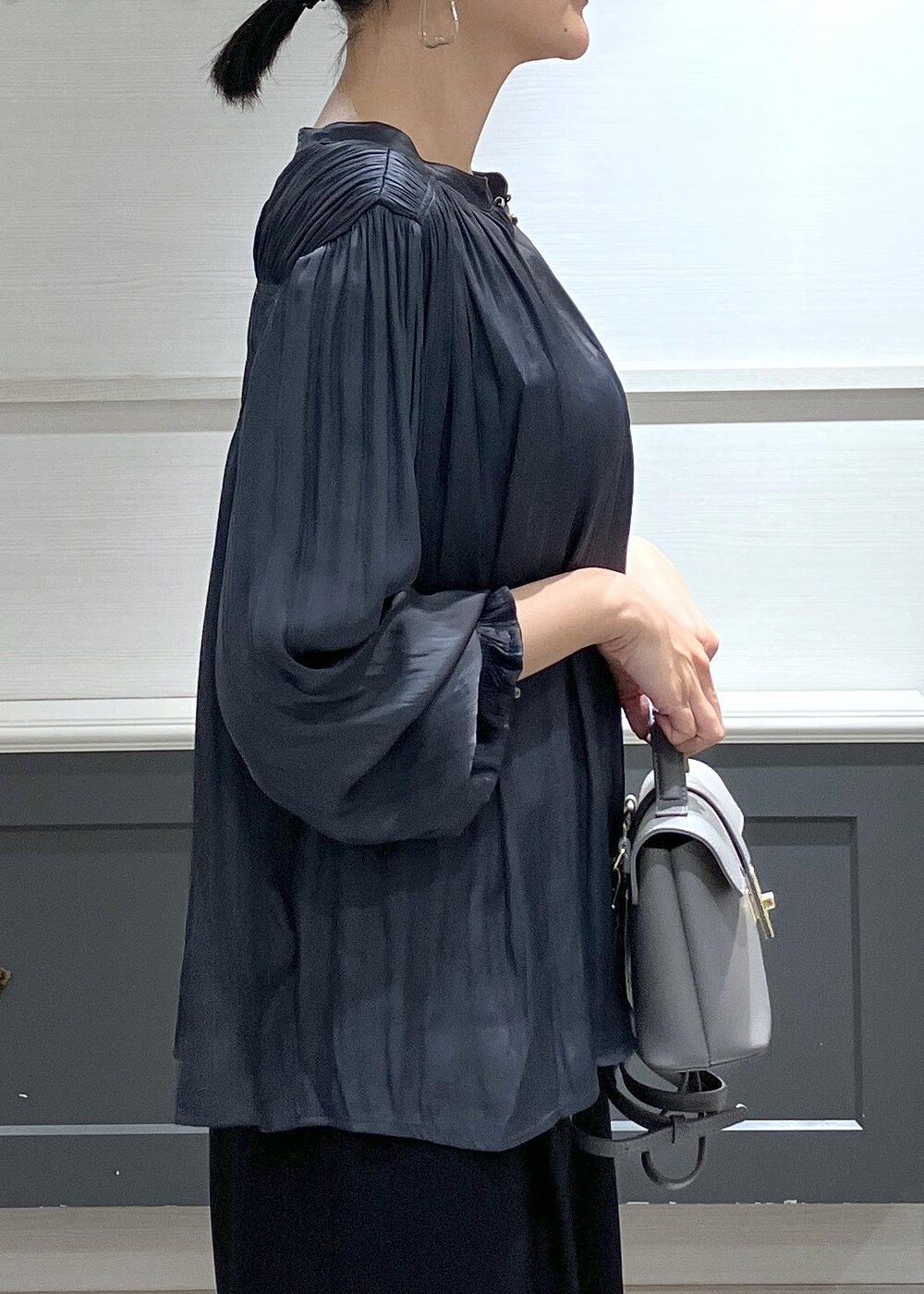 ホワイト系のキャミソール、グレー系のショルダーバッグ、ブラック系のスラックスを着用したレディースの秋コーディネートの8枚目の写真